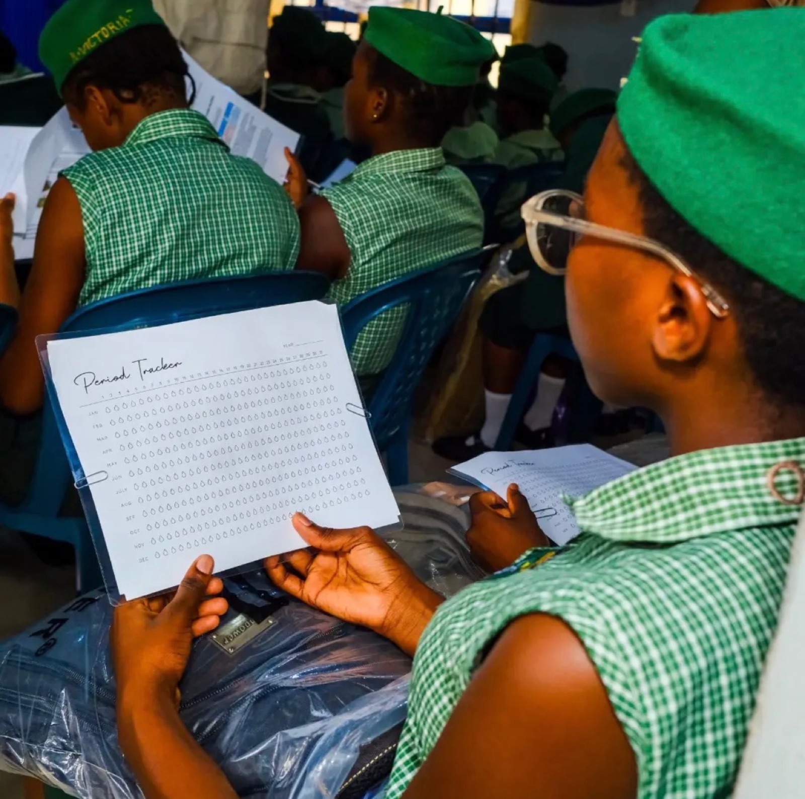 Students studying their health education booklets during KBB's 2026 girls' outreach